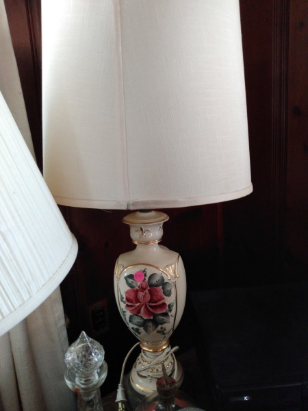 A decorative lamp with an ornate flower on the side.
