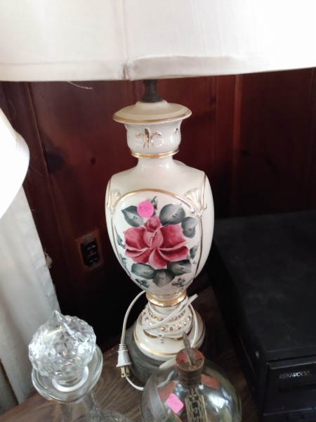 A decorative lamp with an ornate flower on the side.