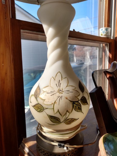 A lamp with a decorative flower on the side.
