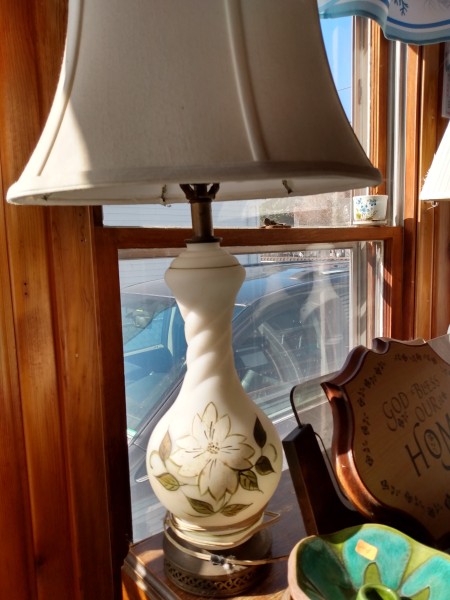 A lamp with a decorative flower on the side.