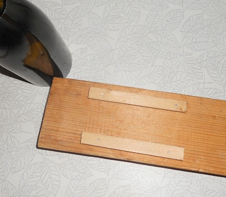 A piece of wood with two smaller pieces of wood attached.