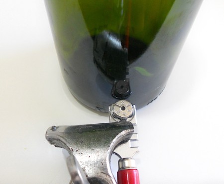 Glass cutter cutting bottom of bottle