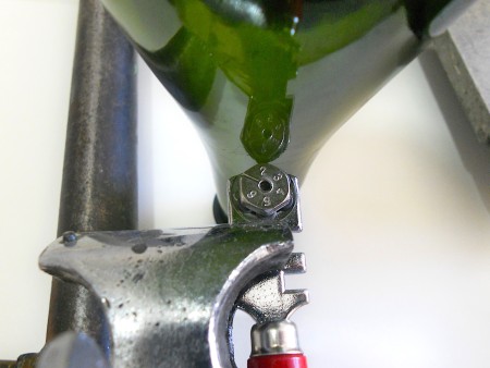 Glass cutter cutting top of bottle.