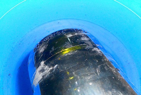 Bottom of bottle being dipped in cold water.
