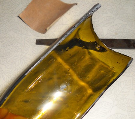 Glass bottle cut in half lengthwise.