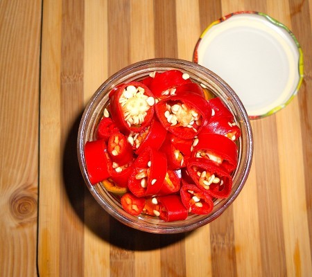 Cut pickled spicy peppers in a jar.