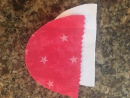 Cutting fabric in an half egg shape.