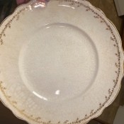 A china plate with golden markings around the edge.