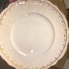 A china plate with golden markings around the edge.