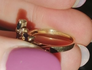 A gold ring with a jeweler's mark inside.