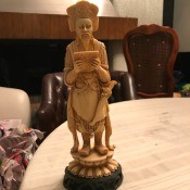An Asian figurine on a pedestal.