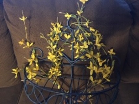 Adding artificial yellow flowers to a wrought iron holder.