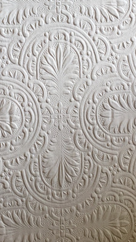 A white textured wallpaper.