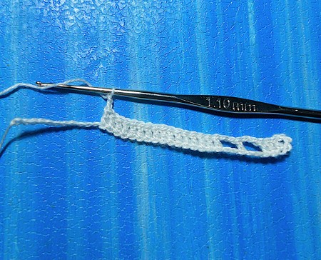 Crocheting a bookmark with white thread.