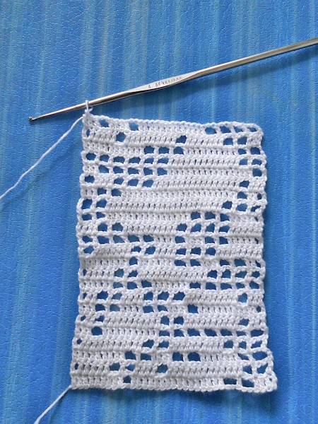 Crocheting a bookmark with white thread.