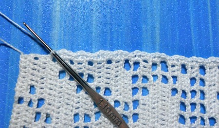 Crocheting a bookmark with white thread.