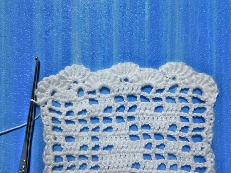 Crocheting a bookmark with white thread.