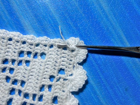 Crocheting a bookmark with white thread.