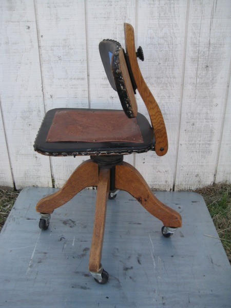 A wooden office chair with a leather seat.
