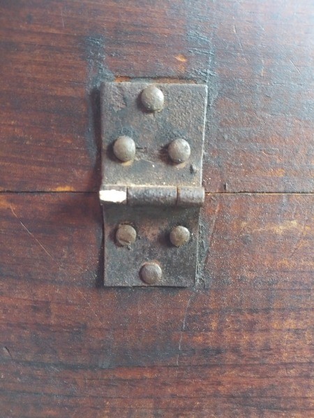 A hinge on an old trunk.