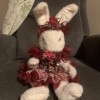 A stuffed bunny wearing a fancy headband and dress.
