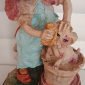 A small figurine of a girl bathing a puppy.