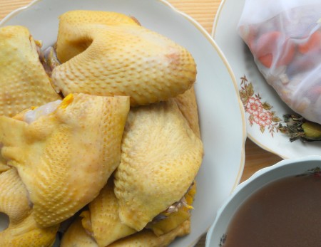 Removing the marinated chicken from the bowl, separating the marinade and veggies.
