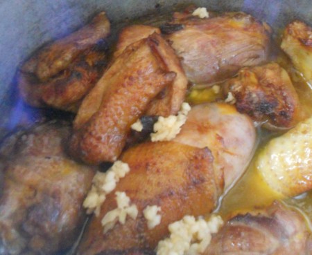 Adding garlic to the chicken pieces.