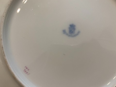 A faded marking on the back of a china plate.