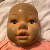 A doll with discolored places on the nose and cheeks.