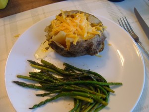 A loaded baked potato with asparagus