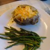 A loaded baked potato with asparagus