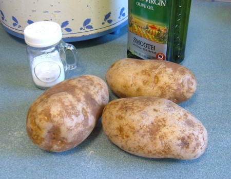 Three baked potatoes with olive oil and salt.