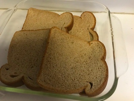 Slices of bread on the bottom of a casserole pan.