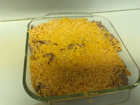 Adding cheese on top of the ingredients.