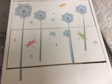 Adding sticker designs to the front of the dresser.