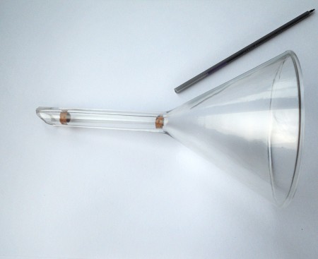 Placing the cork plug in the end of the funnel.