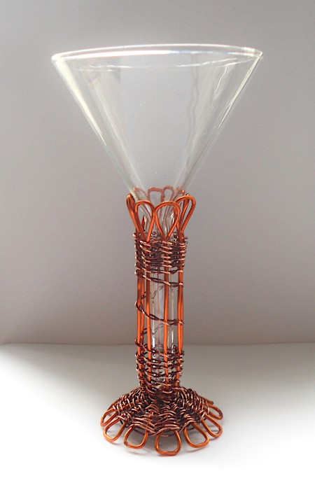 The funnel being held in the copper woven holder.