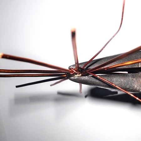 Using pliers to connect the wire to the weavers.