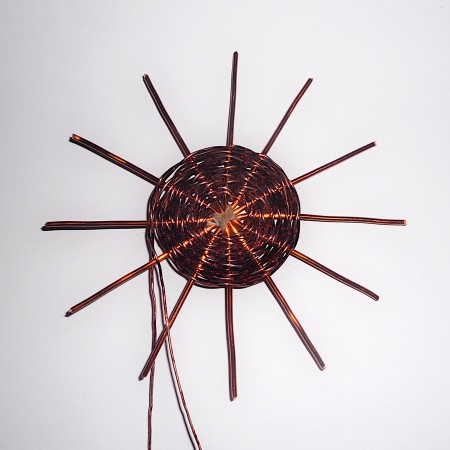 Continuing to weave the wire in a coil.