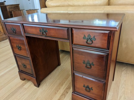 A mahogany desk with drawers.