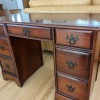 A mahogany desk with drawers.
