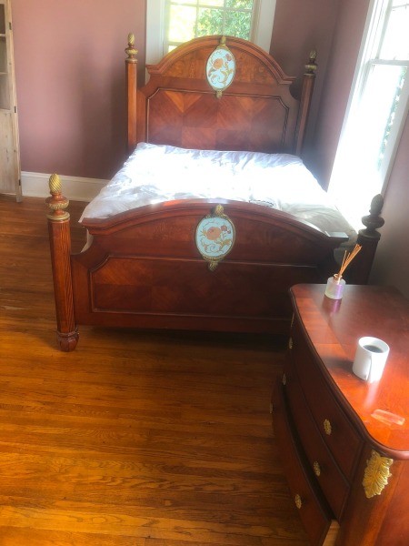A wooden bed frame with an ornate medallion.