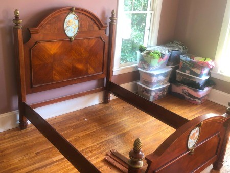 A wooden bed frame with an ornate medallion.