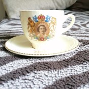 A china cup with the royal seal and a picture of Queen Elizabeth.