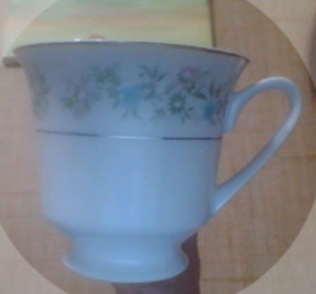 A china cup with delicate flowers around the rim.