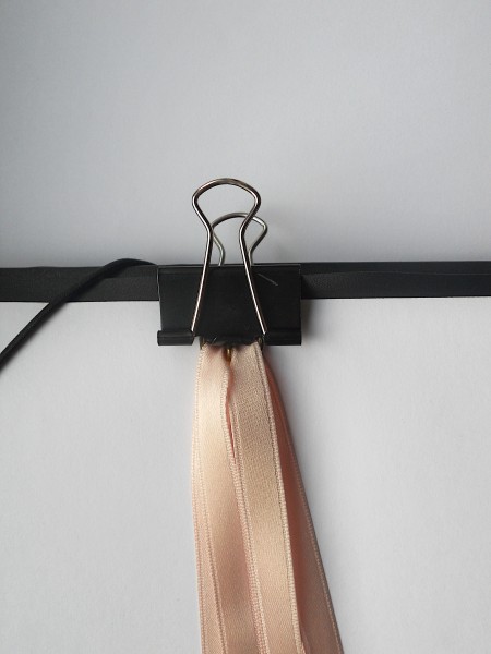 Holding the ribbons with a binder clip.