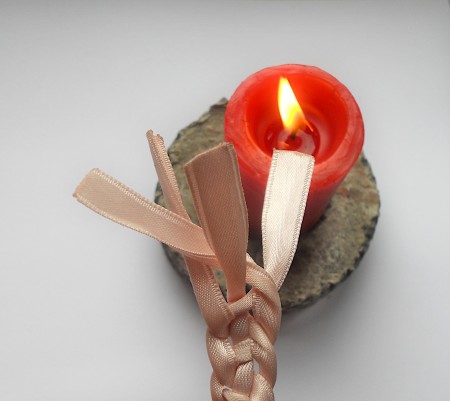 Finishing the ends of a ribbon with a candle flame.