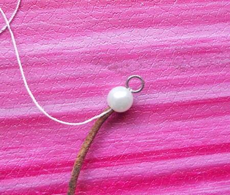 Adding pearls and leather to the thread.