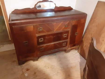 A vintage dresser with a small mirror.